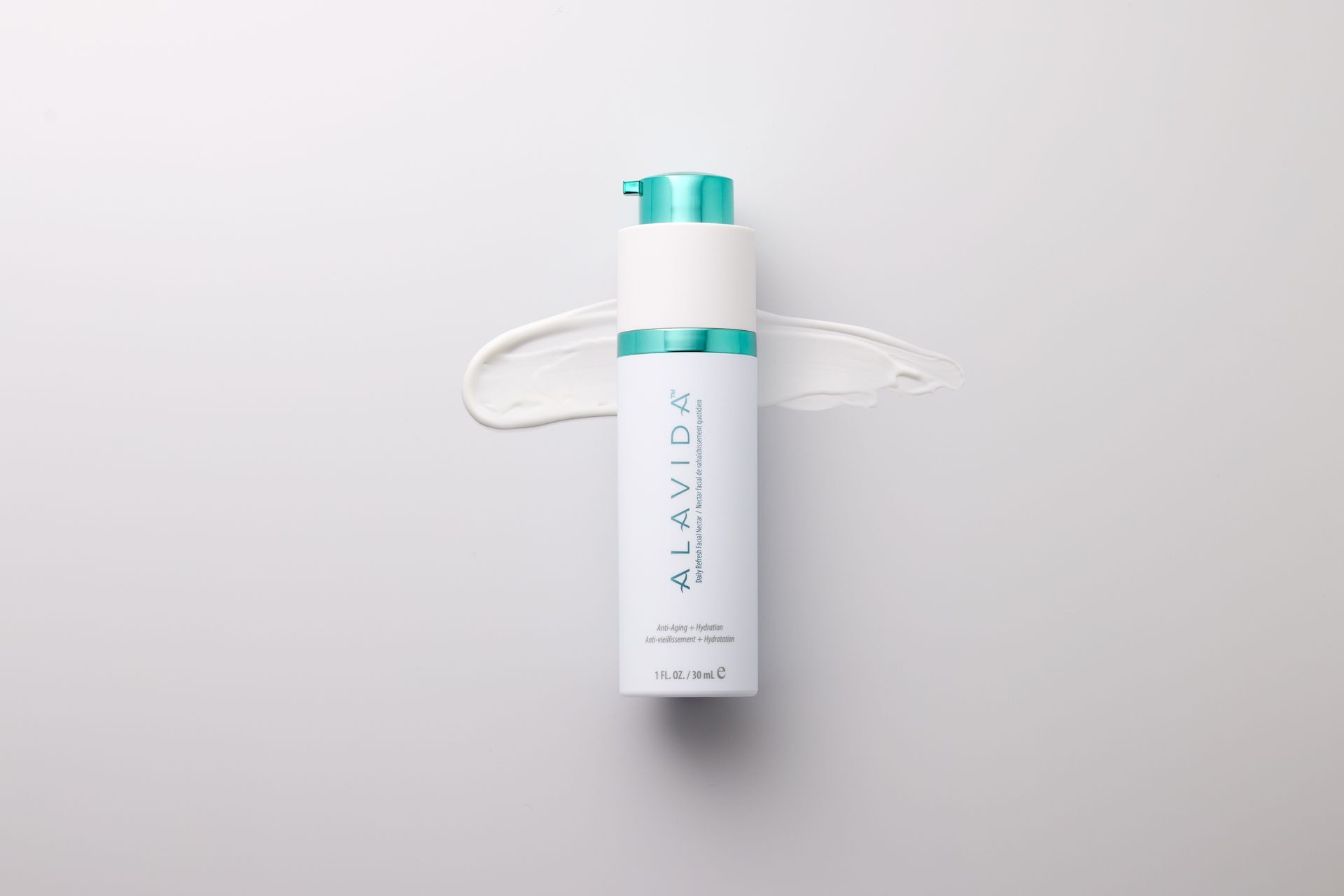 Bottle of Alavida lotion with white cream spread on a light background.