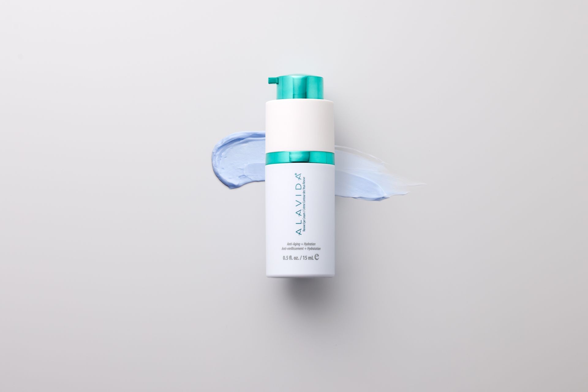 Bottle of Alavida skincare product with blue cream smears on a light background.